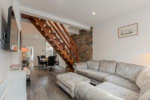 a living room with a couch and a staircase at High End Central Location 2 Bedroom in Stoke on Trent