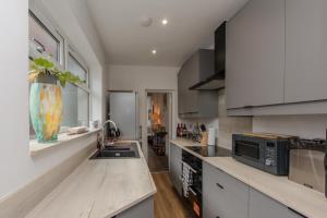 a kitchen with white cabinets and a counter top at High End Central Location 2 Bedroom in Stoke on Trent