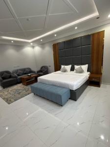 a bedroom with a large bed and a couch at شقق وجهة الوصول in Ar Rawshān