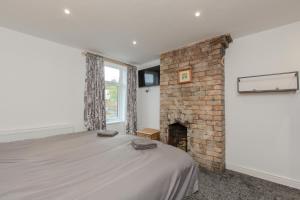 a bedroom with a bed and a brick fireplace at High End Central Location 2 Bedroom in Stoke on Trent