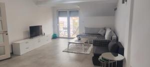 a living room with a couch and a tv at Sofija's Home in Negotino