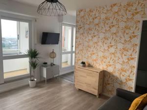 a living room with a couch and a tv at Vue Mer sur Juno Beach - Studio in Courseulles-sur-Mer
