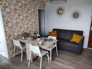 a living room with a table and a couch at Vue Mer sur Juno Beach - Studio in Courseulles-sur-Mer