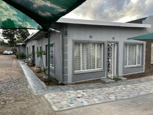a white building with windows on a street at The Family Room in Krugersdorp