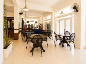 a dining room with black tables and chairs at Satya Graha Hotel Yogyakarta in Yogyakarta
