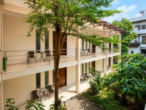 an apartment building with a balcony with chairs at Satya Graha Hotel Yogyakarta in Yogyakarta