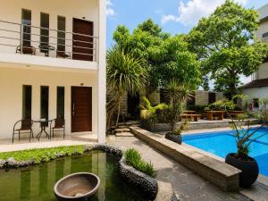 a villa with a swimming pool and a house at Satya Graha Hotel Yogyakarta in Yogyakarta
