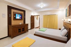 a hotel room with a bed and a tv at Satya Graha Hotel Yogyakarta in Yogyakarta