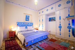 a bedroom with a bed with blue and white at Casa Voyager 'secret garden terrace' in Chefchaouen