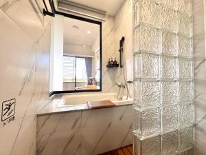 a bathroom with a tub and a window and a sink at 安平胡桃民宿-免費停車-專屬電梯-公園景觀 #包棟可使用娛樂設施 in Tainan +30 photos