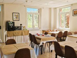 a dining room with tables and chairs and windows at Abbaye de Belval in Troisvaux