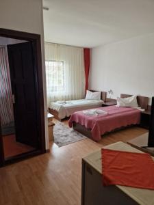 a hotel room with two beds and a window at Riviera Valceana in Râmnicu Vâlcea