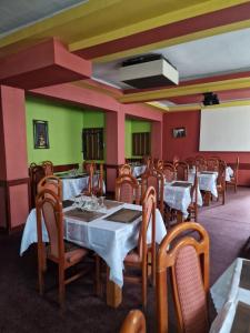 a dining room with tables and chairs and a screen at Riviera Valceana in Râmnicu Vâlcea