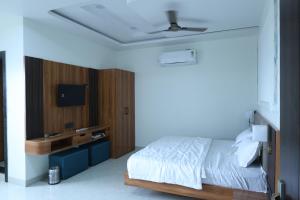 a bedroom with a bed and a flat screen tv at Hotel Radiant Inn in Morena