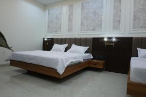 a bedroom with a bed with white sheets and pillows at Hotel Radiant Inn in Morena
