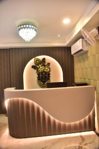 a reception desk with a rooster on the wall at Hotel Radiant Inn in Morena