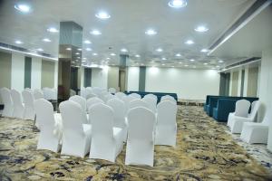 a conference room with white chairs and a stage at Hotel Radiant Inn in Morena