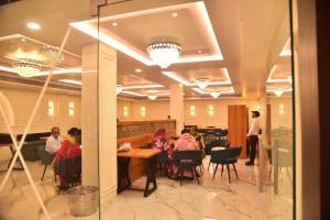 a group of people sitting at a table in a restaurant at Hotel Radiant Inn in Morena