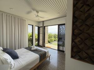 a bedroom with a bed and a large window at Cooktown Getaway in Cooktown