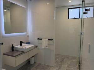 a white bathroom with a sink and a shower at Cooktown Getaway in Cooktown +15 photos