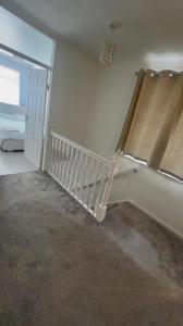 a room with a bed and a window with a curtain at The Stanford Home in Horndon on the Hill +2 photos