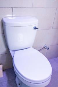 a bathroom with a white toilet in a room at WN Apartments in Lusaka +39 photos