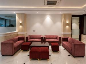a waiting room with red couches and a table at Hotel Velvet The Ultimate in Prayagraj