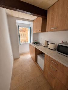 a kitchen with wooden cabinets and a counter top at Republic Stay in Valletta