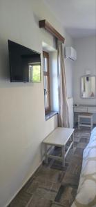 a living room with a tv on the wall at Hotel Adonis in Mythimna
