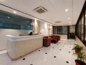 a lobby with a bar and chairs and a person at Hotel Velvet The Ultimate in Prayagraj