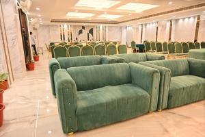 a row of green couches in a room at Hotel Velvet The Ultimate in Prayagraj
