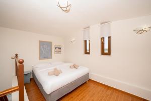 a bedroom with a white bed with two teddy bears on it at Theros Maisonette by A&D Properties in Porto Rafti