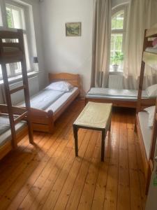 a bedroom with two bunk beds and a bench at Baltic Home in Polanica-Zdrój