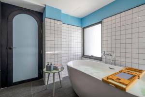 a bathroom with a white tub and a window at CMYK Boutique Hotel in Bangkok +50 photos
