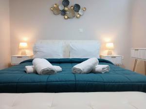 a bedroom with a blue bed with towels on it at Malvazios Villas Azure Sea Villa in Gythio +79 photos