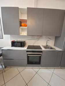 a kitchen with a sink and a microwave at Atene Bilocale in affitto breve in Milan