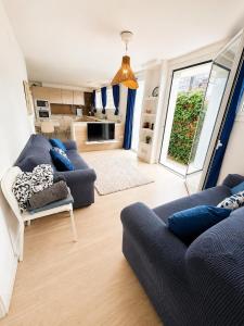 a living room with two blue couches and a kitchen at Apartamento con piscina cerca de Barcelona in El Masnou