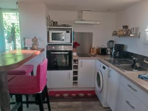 a kitchen with a stove and a microwave at Chez Delph in Rognonas +1 photo