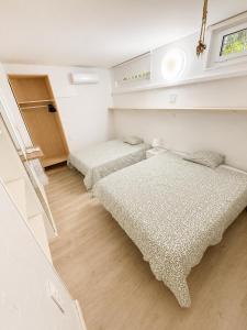 a bedroom with two beds and a window at Apartamento con piscina cerca de Barcelona in El Masnou +19 photos