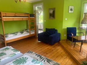 a room with two bunk beds and a table and a chair at Baltic Home in Polanica-Zdrój