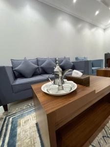 a living room with a blue couch and a coffee table at شقق وجهة الوصول in Ar Rawshān