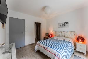 a white bedroom with a bed and a tv at Le Reve Mimizan Plage in Mimizan-Plage
