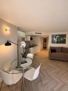 a living room with a glass table and white chairs at Noa's Place in Eilat