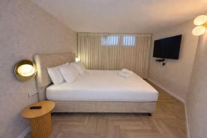 a hotel room with a bed and a television at Noa's Place in Eilat