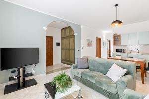 a living room with a couch and a flat screen tv at Estay - Casa Bo' in city center - AirCon - WiFi in Tortolì