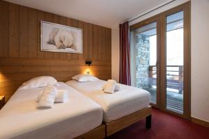a bedroom with two beds with towels on them at Résidence Almes 1 et Almes 2 by Alpapart in Tignes