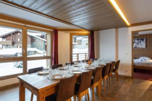 a large dining room with a long table and chairs at Résidence Almes 1 et Almes 2 by Alpapart in Tignes