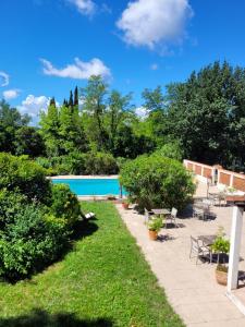 a backyard with a swimming pool and trees at Villa Sainte BARBE in Loriol-du-Comtat