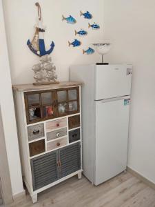 a kitchen with a white refrigerator and a cabinet at Domus Vida in Quartu Sant'Elena