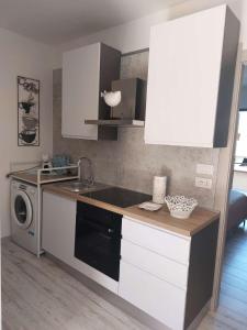 a kitchen with a sink and a washing machine at Domus Vida in Quartu Sant'Elena +11 photos